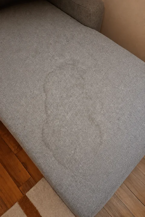 Tache constatée sur l’assise d’un canapé gris